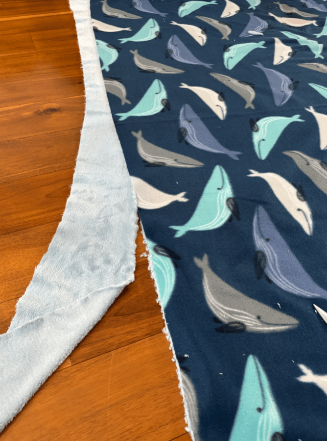 A close up of cartoon blue whale fabric, with the edges cut off to better align.